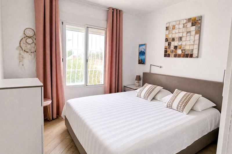 Double bedroom with a white bed and light walls